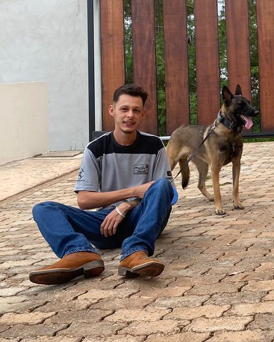 Vinicius, anfitrião do Village do Sol, com seu cachorro na entrada dos chalés